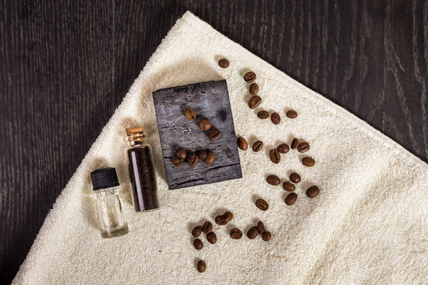 ブラウンのスパ: 天然石けん、アロマオイル、コーヒー豆、ウッドの背景にタオル. - 写真・画像