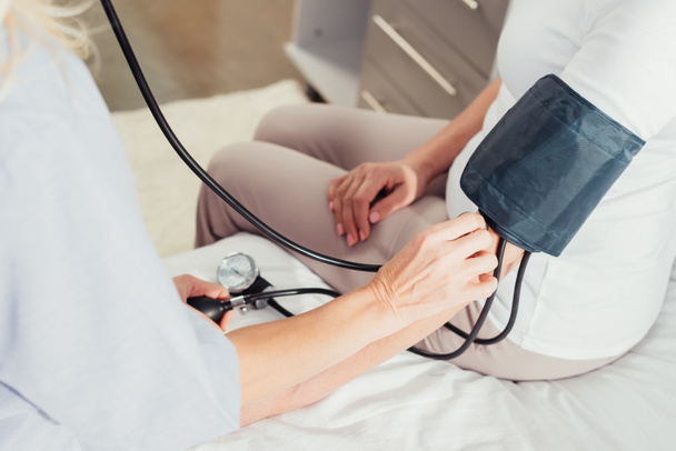 Enfermera midiendo la presión arterial al paciente - Foto, Imagen