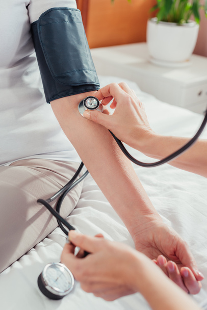 Enfermera midiendo la presión arterial al paciente - Foto, Imagen