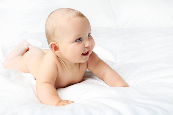 Little newborn baby on white bed - Zdjęcie, obraz