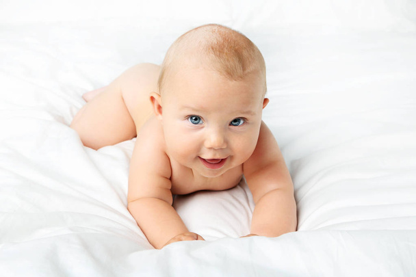 Little newborn baby on white bed - Fotó, kép