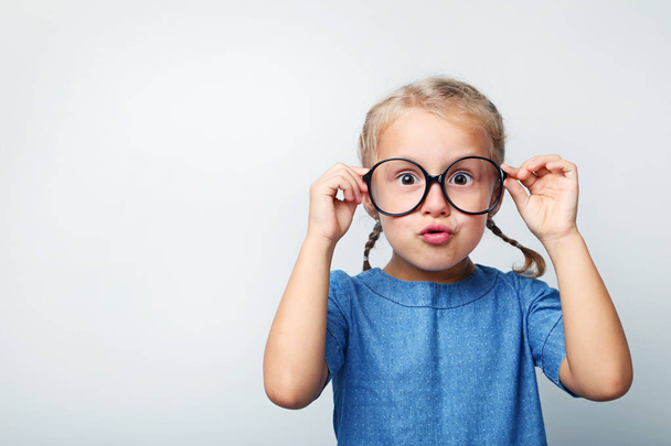 Portrait of little girl with glasses on grey background - Photo, image