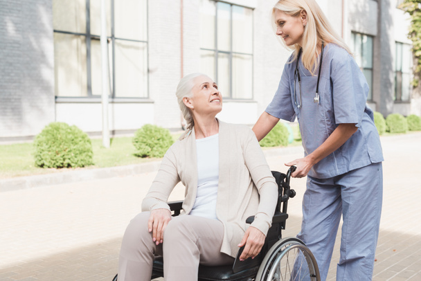 enfermeira e mulher idosa em cadeira de rodas
 - Foto, Imagem