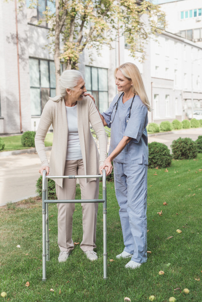 sairaanhoitaja ja vanhempi potilas kävelijällä
 - Valokuva, kuva