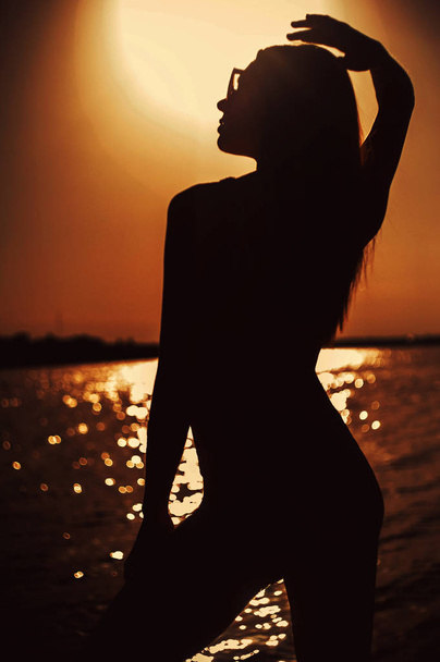 schöne junge Frau ta Sonnenuntergang - Foto, Bild