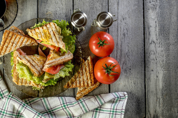 Panini sandwich with ham, tomato and lettuce. - Фото, зображення