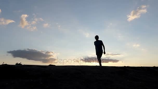 junger Mann springt hoch und lächelt in einer bergigen Gegend bei Sonnenuntergang im Slo-mo - Filmmaterial, Video