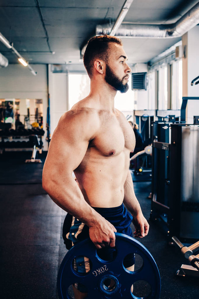 Muscular guy in the gym - Фото, изображение