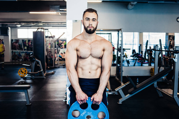 Muscular guy in the gym - Фото, изображение