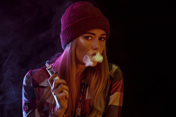 young woman smoking electronic cigarette - Foto, afbeelding