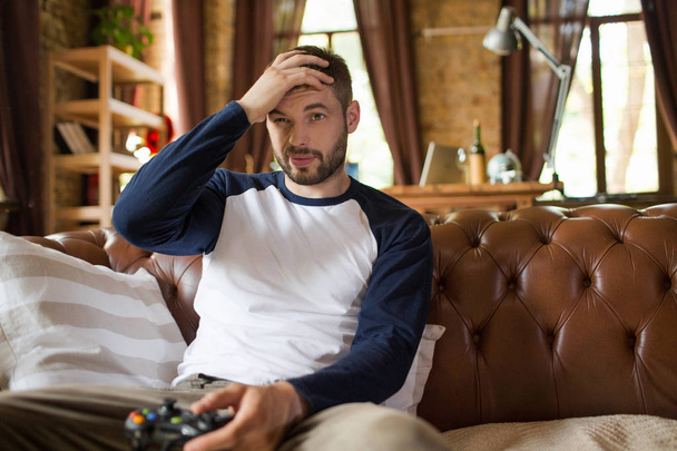 Emotional young guy with joystick in hands. - Photo, Image