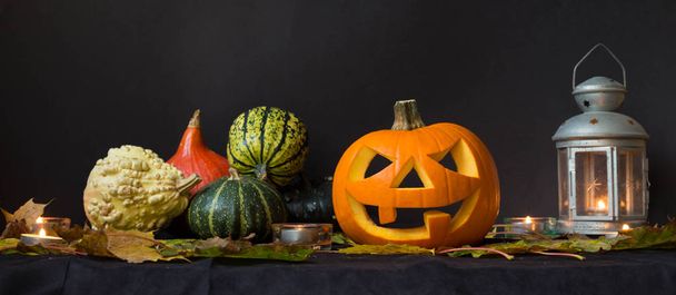 Zucche di Halloween tra candele, foglie autunnali e vecchia lampada lunatica
 - Foto, immagini