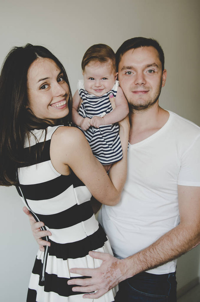 hermosa joven familia sosteniendo pequeño bebé y sonriendo
  - Foto, imagen