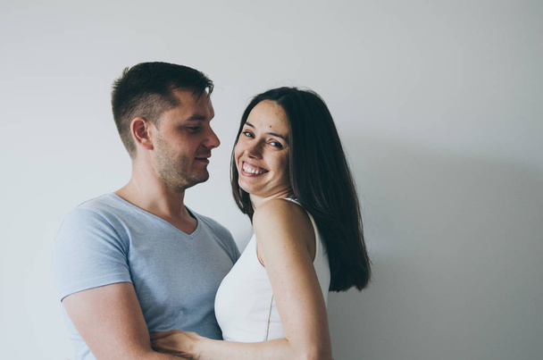  schönes junges Paar umarmt und lächelt auf weißem Hintergrund  - Foto, Bild
