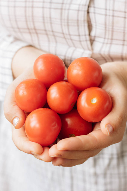Mujer sosteniendo tomates cherry frescos y maduros en las manos. - Foto, Imagen