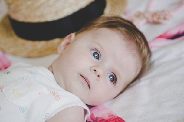 Όμορφο μωρό κοριτσάκι με λευκό κοστούμι σώμα ψάχνει στην κάμερα - Φωτογραφία, εικόνα