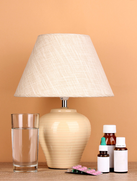table lamp and medicines on beige background - Zdjęcie, obraz