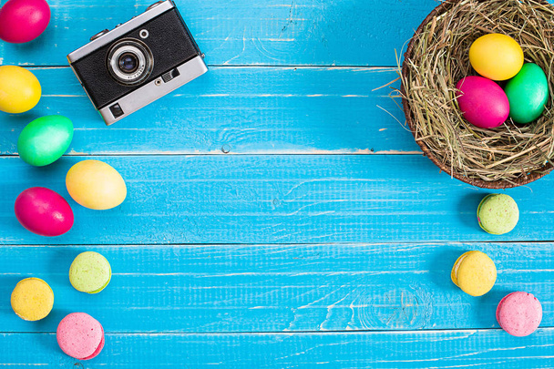 Œuf de Pâques coloré dans le nid sur panneau de bois bleu
. - Photo, image