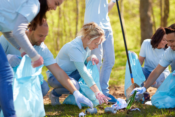 volunteers with garbage bags cleaning park area - Foto, Imagen