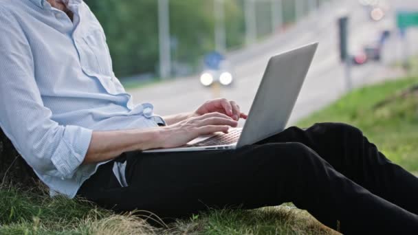 ein junger Mann mit einem Laptop im Freien - Filmmaterial, Video