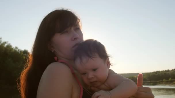 Maminka má dítě v náručí, rodinnou dovolenou na pláži v létě - Záběry, video