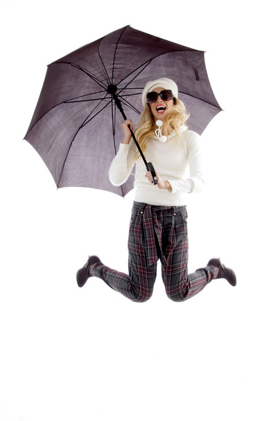 Jumping woman holding an umbrella - Valokuva, kuva
