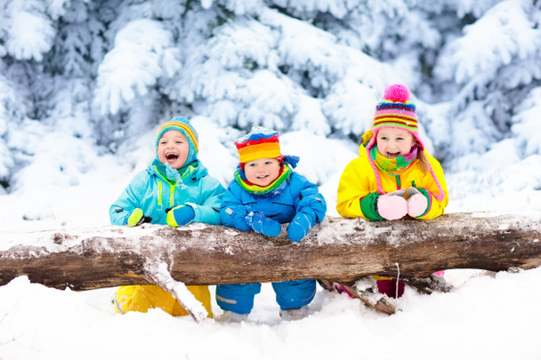 Des enfants qui jouent dans la neige. Les enfants jouent dehors dans les chutes de neige d'hiver
. - Photo, image