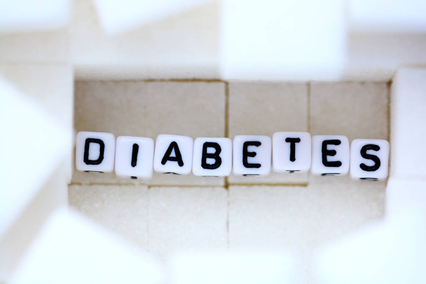 Diabetes ziekte concept met kubieke witte suiker als achtergrond - Foto, afbeelding