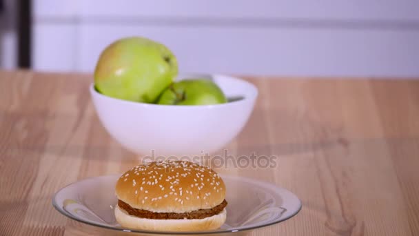 Close up apples and burger on a plate - Πλάνα, βίντεο