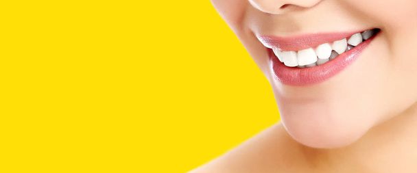 Pretty woman smiling against a yellow background with copyspace - Photo, Image