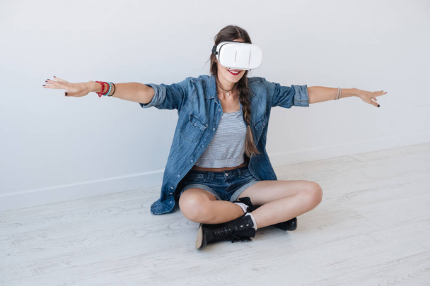 Flying girl while using VR glasses - Foto, afbeelding