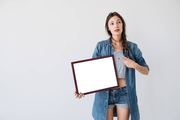 Mädchen zeigt einen leeren Rahmen - Foto, Bild