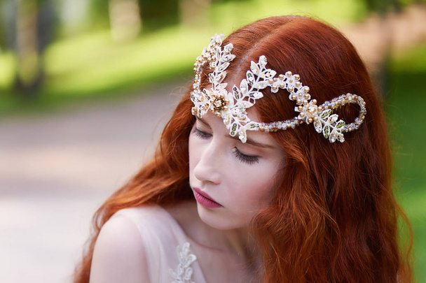 Beautiful red-haired girl with long curly hair in the bride, in a long lace dress.A natural beauty. - Zdjęcie, obraz