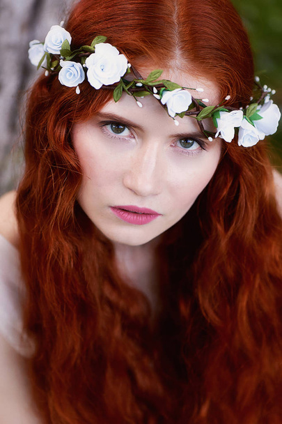 Beautiful red-haired girl with long curly hair in the bride, in a long lace dress.A natural beauty. - 写真・画像