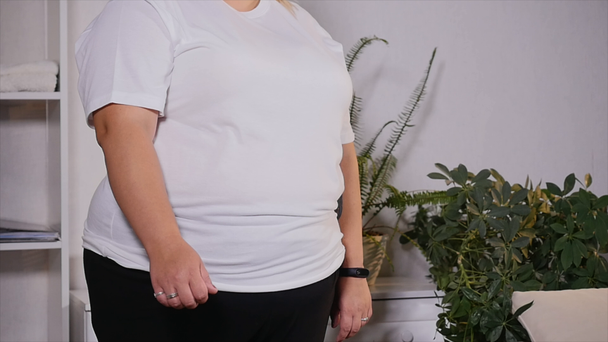 tlustá žena stojí na váhy a začne se radovat - Záběry, video