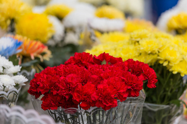 A bouquet of red carnations and other flowers are sold in the city market. - Photo, image