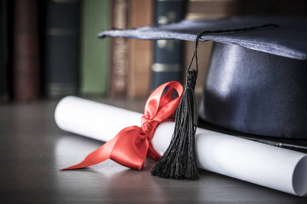 Sombrero de graduación y diploma en la mesa
 - Foto, imagen