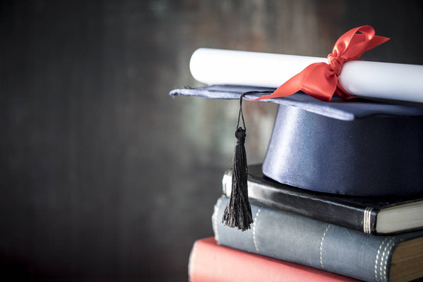 Afstudeer hoed en diploma op tafel - Foto, afbeelding