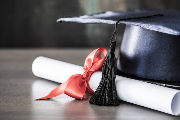 Chapéu de graduação e diploma na mesa
 - Foto, Imagem