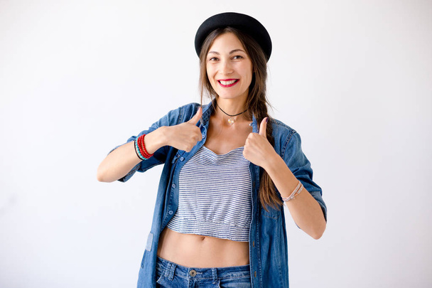 Портрет молодой женщины в шляпе с большими пальцами вверх
 - Фото, изображение