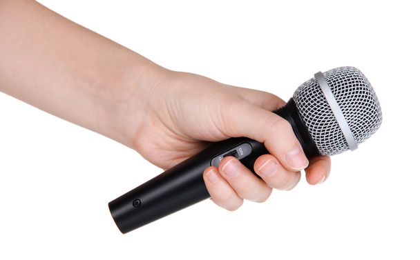 Black microphone in hand isolated on white - Photo, image