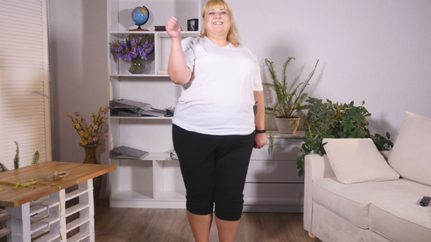 fat woman stands on the scales, dancing and shows class - Felvétel, videó