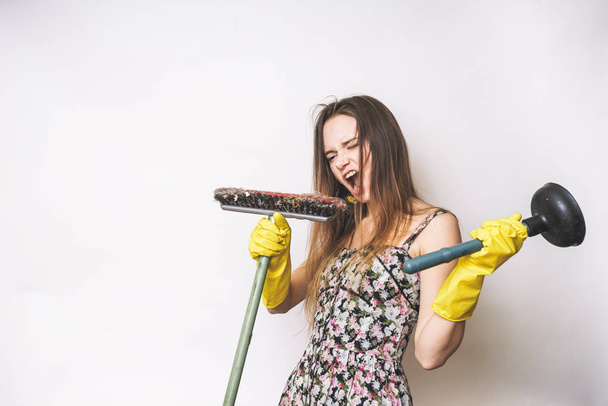 Woman cleaner singing  with mop and plunger - Photo, image