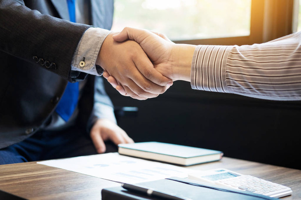 Due uomini d'affari fiduciosi stringono la mano durante una riunione nel
 - Foto, immagini