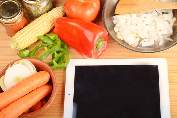 Vegetables and seasonings with a digital tablet. - Foto, imagen