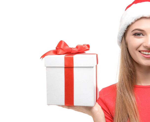Beautiful young woman in Santa hat holding giftbox, on white background - Foto, afbeelding