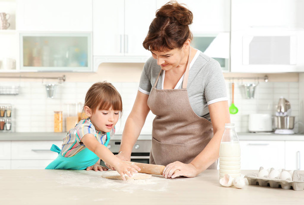 Little girl and grandmother on kitchen - Фото, зображення