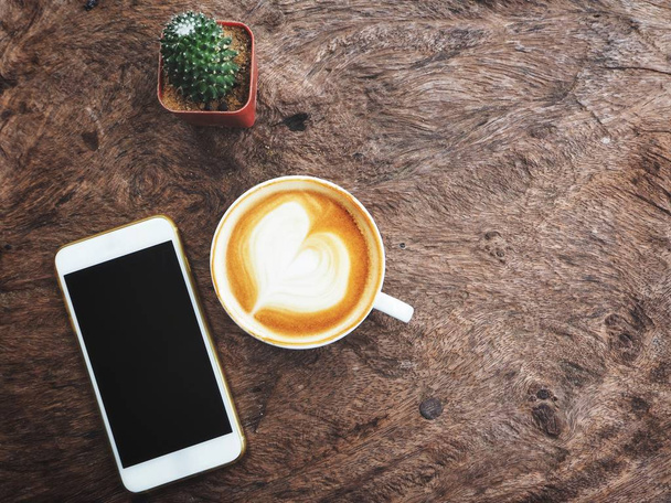 Kávéscsésze smartphone fából készült háttér - Fotó, kép