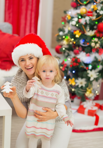 Portrait of smiling mother and baby with Christmas tree cookies - Фото, зображення
