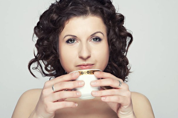 portrait of a young girl drinking tea and a tea cup - Foto, afbeelding